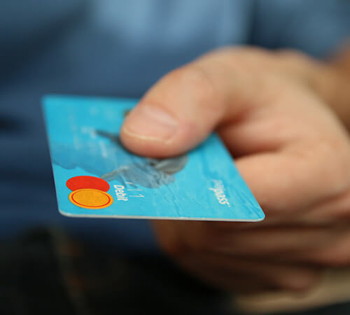 Hand holding a blue credit card